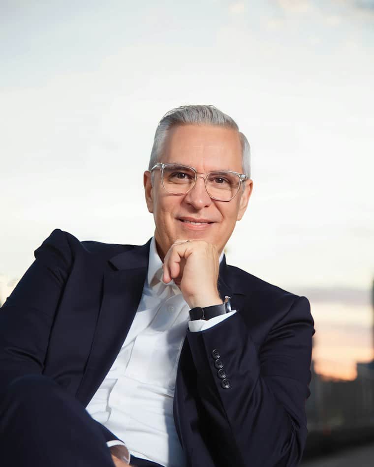 Mature business owner sitting with his hand on his chin, considering selling his business
